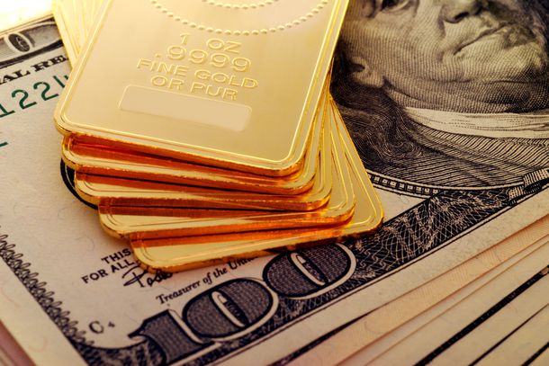 Gold bars on top of $100 bills